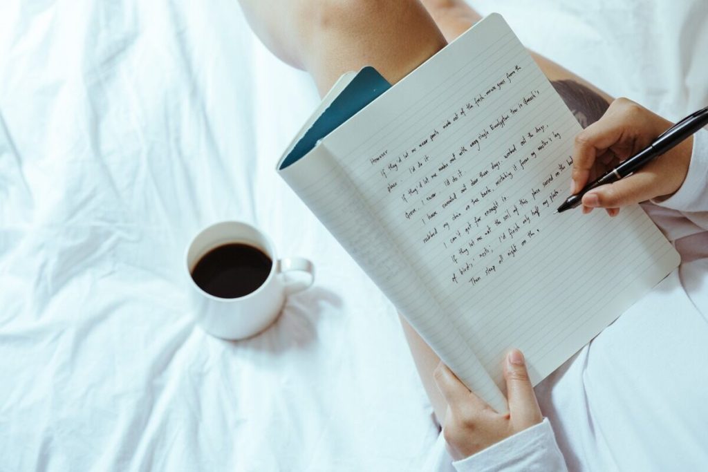 Woman writing a note - Self-Awareness Coaching Tools