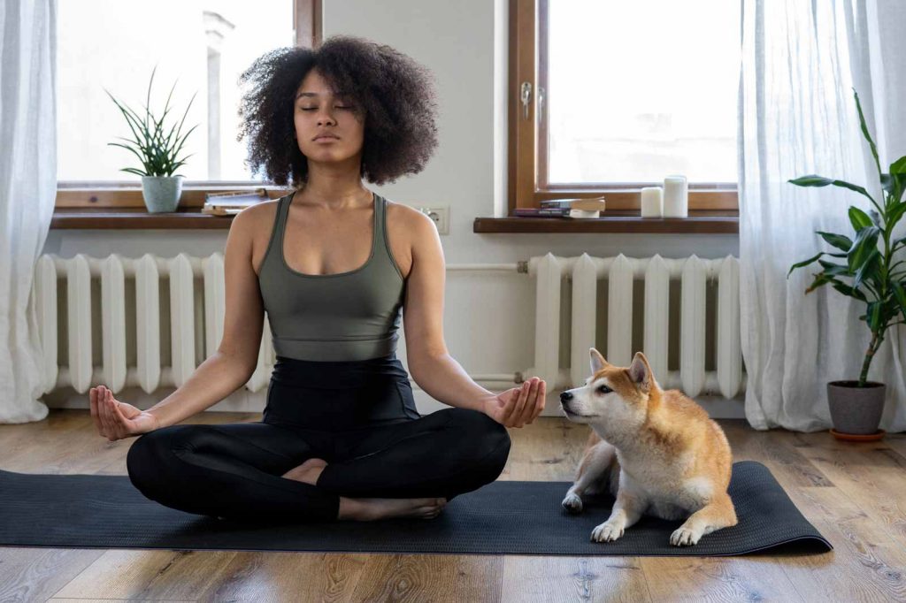 Woman meditating with dog - Use Headspace to build a meditation habit