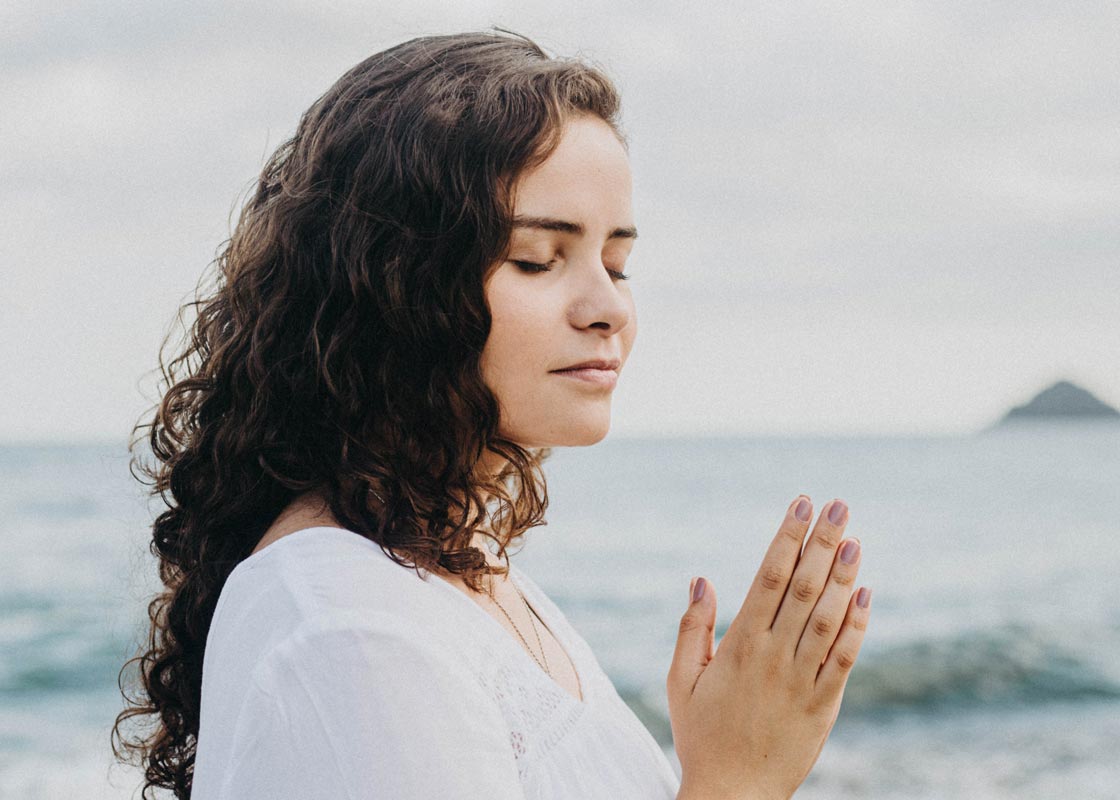 woman meditating by the ocean