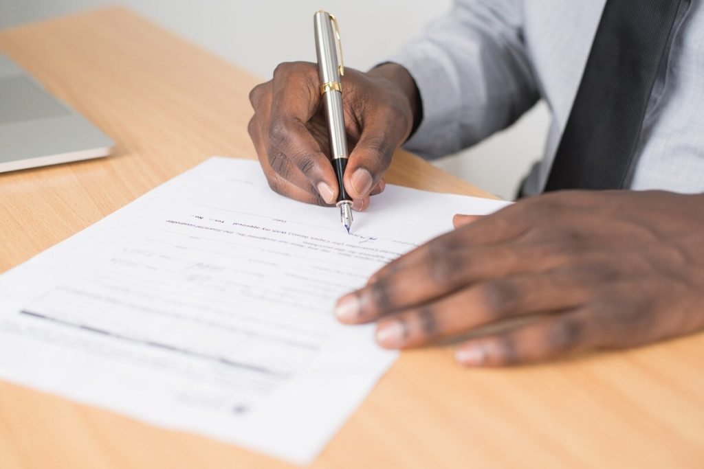 Man signing a document from a welcome packet