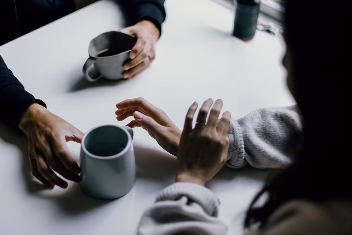 Two people on a table drinking coffee