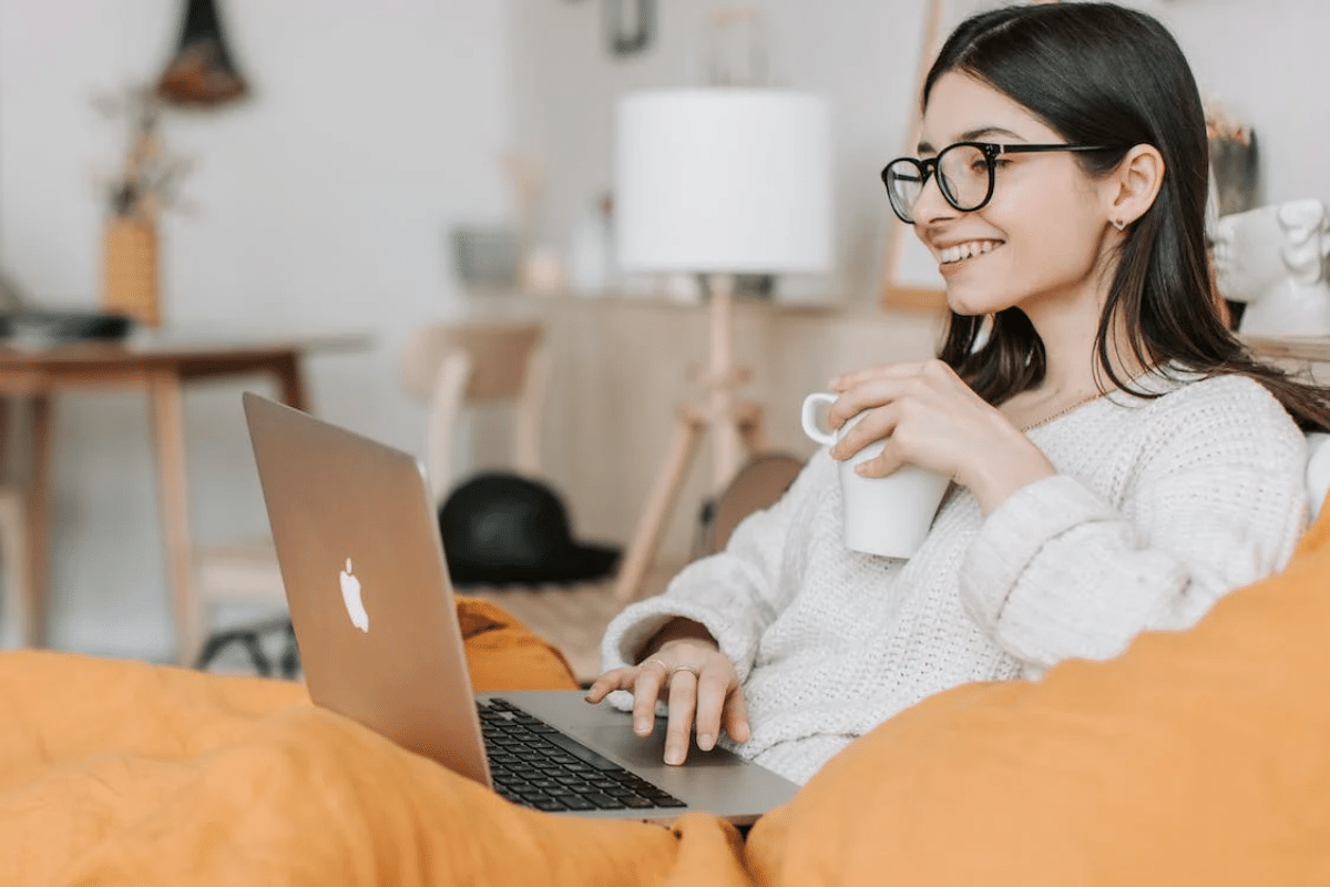 Woman drinking coffee while using laptop